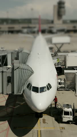Various commercial aircraft are stationed on the bustling airport runway, ready for takeoff
