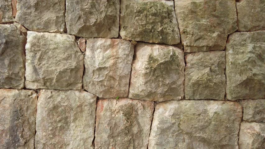Smooth camera pan revealing a perfectly formed medieval stone wall made of large stones