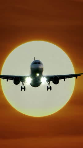 An Airplane is Landing Against the Backdrop of a Beautiful Sunset, Creating a Stunning View
