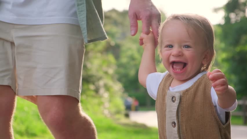 A father and son share joyful moments in a lively park, embodying family love