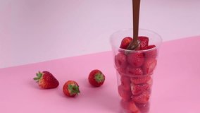 Process of pouring strawberry berries with melted liquid chocolate in cup. Sweet food, dessert on pink background. - Powered by Shutterstock - Get 15% off with code: PIKWIZARD15