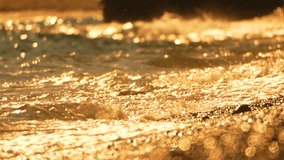 Golden sunset on the beach. Foamy waves rolling towards golden sand beach under low warm sun light. Slow motion. Nobody. Holiday recreation concept. Abstract nautical summer ocean sunset nature. - Powered by Shutterstock - Get 15% off with code: PIKWIZARD15