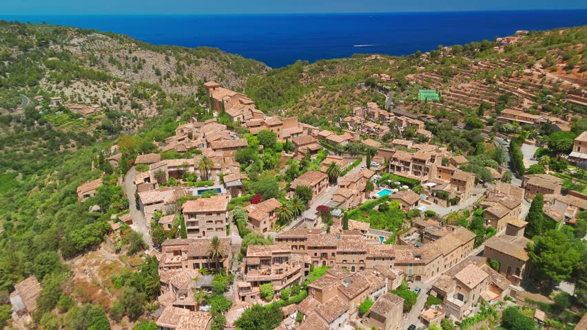 Deia town, Mallorca, Balearic Islands, Spain. Aerial view of picturesque mountain village with stone houses and rustic rooftops, Deia, Majorca, Spain.