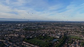 Bristol Ballon Fiesta in late afternoon, golden hour, summer. Dozens of hot air balloons flying over the cityscape horizon. Filmed with 4K drone - Powered by Shutterstock - Get 15% off with code: PIKWIZARD15