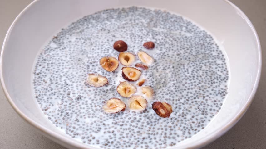 Chia pudding with hazelnuts and maple syrup, white background. Healthy vegan breakfast.