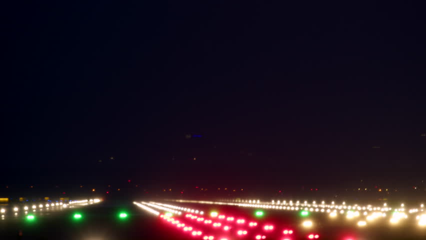 Commercial airplane landing at night with runway lights