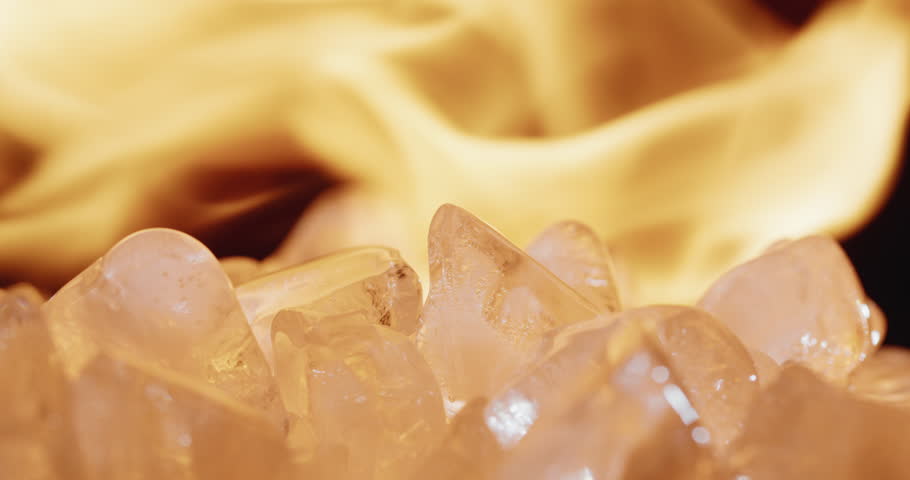 The flame lights up over pieces of ice, tongues of fire are reflected in the surface of the ice