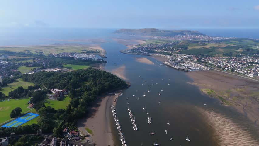 Coastal towns and forest around The Conwy River and estuary in North Wales. With sail boats, houses and sandbanks. Great Orme in the background.