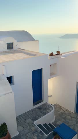 Beautiful sunset in Santorini island, Greece. White architecture with sea view. Blue sea and the blue sky at sunset. Vertical video
