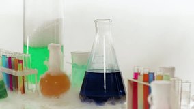 Conducting chemical experiments in the laboratory. Test tubes with colored liquids, lots of smoke and foam. Close up. - Powered by Shutterstock - Get 15% off with code: PIKWIZARD15