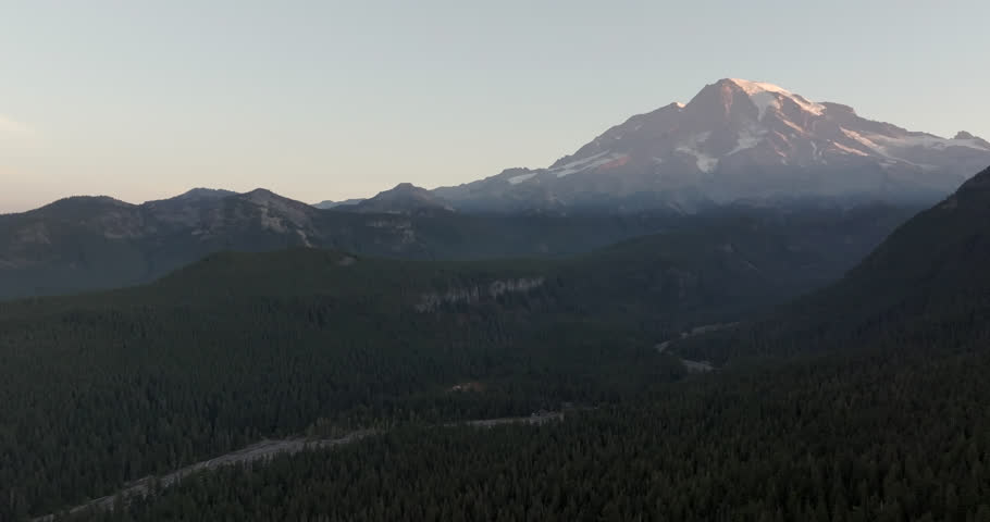 Mount Rainier at sunset with shadowed valleys and forested slopes in Washington State, USA