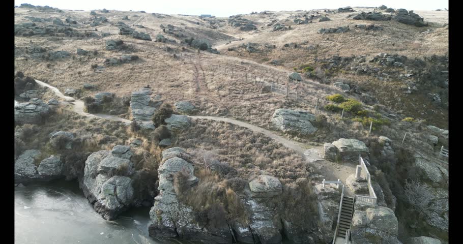 A drone footage over a rocky mountain at Butchers Dam Reservoir at the daytime in Otago Region, New Zealand