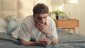 Serious Caucasian man bed using mobile phone smartphone guy male technology pensive problem frown error rejection fail broken gadget spam connection notification stressful worry wrong trouble banking - Powered by Shutterstock - Get 15% off with code: PIKWIZARD15