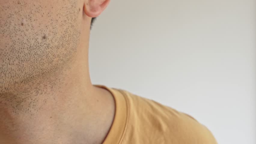 A man uses an electric shaver in a close-up, demonstrating his grooming routine