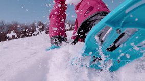 SLOW MOTION, TIME WARP, LOW ANGLE, CLOSE UP: Playful young woman wearing snowshoes runs in the deep powder snow. Female tourist having fun snowshoeing in the sunny Alps, kicking up big pieces of snow. - Powered by Shutterstock - Get 15% off with code: PIKWIZARD15