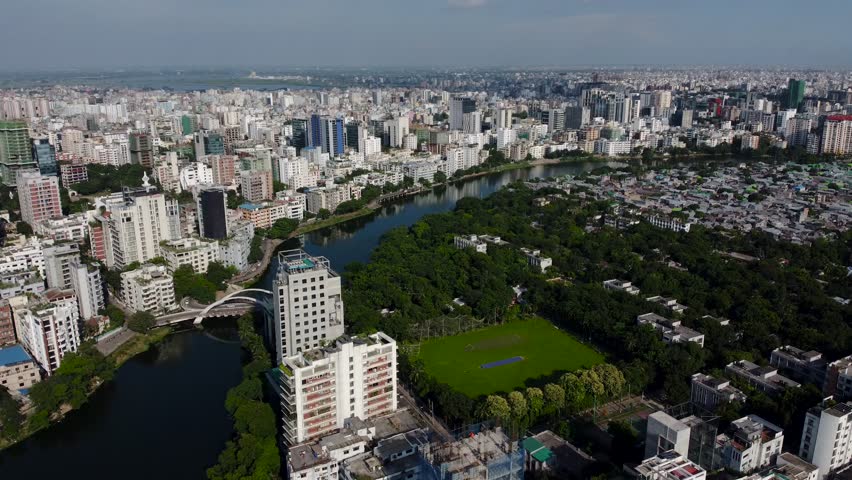 A drone cityscape view, showing urban buildings with lake and a lush park on a sunny day in Dhaka, Bangladesh