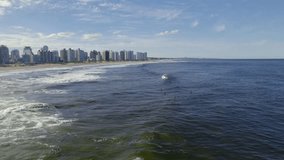 A drone footage of Brava Beach with the urban buildings in the background on a sunny day in Punta del Este city, Uruguay - Powered by Shutterstock - Get 15% off with code: PIKWIZARD15