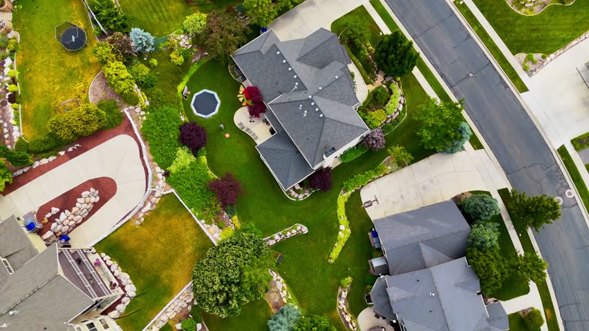 A drone view showing luxurious houses with greenery and paved road in North Salt Lake City, Utah on a sunny day