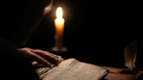 Video of old monk reading old book in dark monastic cell room. Priest in glasses with medieval religious old book under candle light at night time.
 - Powered by Shutterstock - Get 15% off with code: PIKWIZARD15