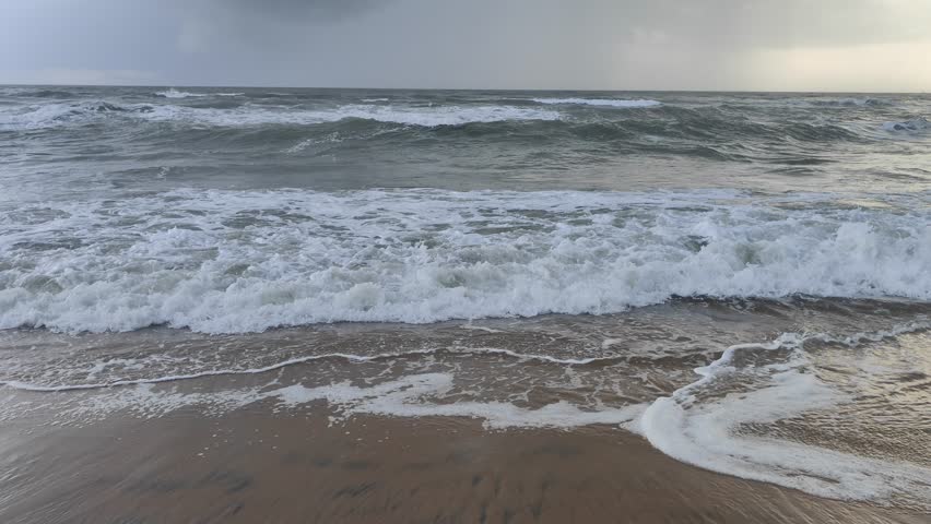 Dangerous high tide wave on the beach.Closeup slow motion of a huge powerful sea wave rising at the shore of the Beach at Goa in India. Sea wave in the beach. Powerful wave of the ocean due to strong.