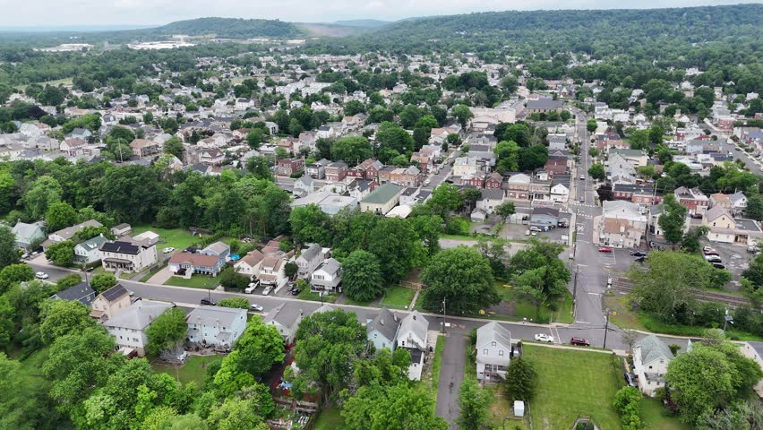 A drone cityscape view of Bound Brook town showcasing urban buildings, roads and green trees at the daytime in New Jersey