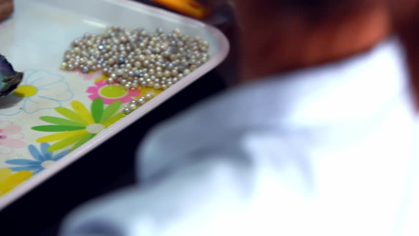 Traditional Vietnamese oyster pearl farm industry, an opened oyster reveals a stunning and beautiful pearl inside, displayed on the table in Vietnam, the natural beauty of ocean treasures cultivated