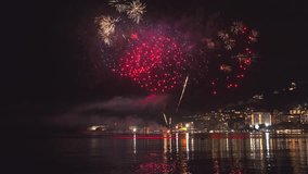 Bright fireworks exploding with colorful lights over sea shore and small mediterranean town, 4k - Powered by Shutterstock - Get 15% off with code: PIKWIZARD15