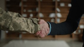 Close up unrecognizable Caucasian officer in camouflage uniform man military army soldier veteran shaking hands businessman male business partner handshake inside apartment office. Partnership respect - Powered by Shutterstock - Get 15% off with code: PIKWIZARD15