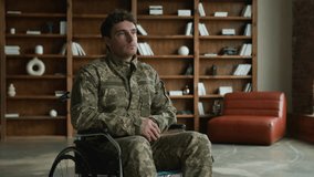 Sad pensive depressed young Caucasian male military officer veteran warrior man with disability guy soldier wheelchair looking distance contemplating think indoors office. Mental health problems PTSD - Powered by Shutterstock - Get 15% off with code: PIKWIZARD15