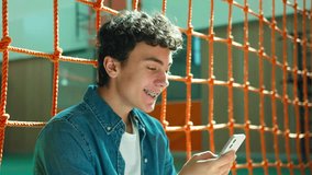 Caucasian male boy teen Hispanic guy pupil Latina man teenager student looking at mobile phone achieve excited amazed surprised wonder reading good news online smartphone at school university college - Powered by Shutterstock - Get 15% off with code: PIKWIZARD15
