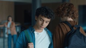 Caucasian male man guy pupil student schoolboy teenager walking going in corridor hallway in university college school sad upset bullying classmate boy pushing shoulder push bully violence problem - Powered by Shutterstock - Get 15% off with code: PIKWIZARD15