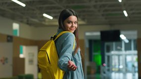 Back view Caucasian girl female woman student pupil education studying walking in school walk in university college corridor turn around invite come here gesture invitation motivate join go to lesson - Powered by Shutterstock - Get 15% off with code: PIKWIZARD15