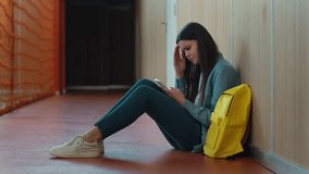 Caucasian sad upset frustrated stressed bad feeling female girl woman schoolgirl pupil student at school university college corridor looking at mobile phone screen using smartphone bad news headache - Powered by Shutterstock - Get 15% off with code: PIKWIZARD15