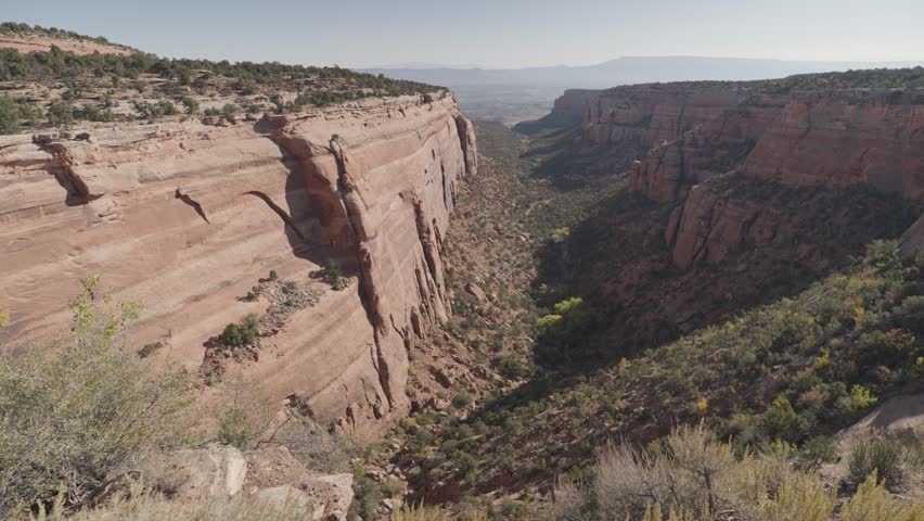 Colorado National Monument Park near the city of Grand Junction. Sheer-walled, Red rock canyons, Rim Rock Drive, Towering monoliths within a vast plateau and canyon panorama USA