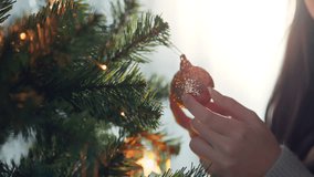 Close-up hand of woman decorating Christmas tree with baubles balls on the background of festive lights at home on calm winter evening, Christmas and new year concept. - Powered by Shutterstock - Get 15% off with code: PIKWIZARD15