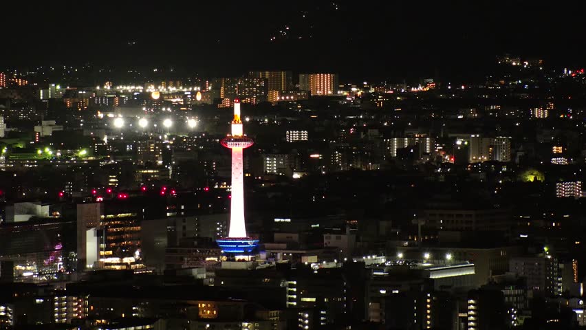KYOTO, JAPAN - DECEMBER 2021 : Aerial high angle view of Kyoto city at night. Scenery of streets and buildings around Kyoto station. Time lapse shot. Japanese urban nightlife city concept video.
