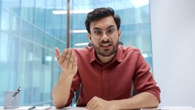 Webcam view. Angry excited businessman arguing on video call looking at camera sitting at workplace in business office. Dissatisfied stressed man emotionally talks about problems expressing anger - Powered by Shutterstock - Get 15% off with code: PIKWIZARD15