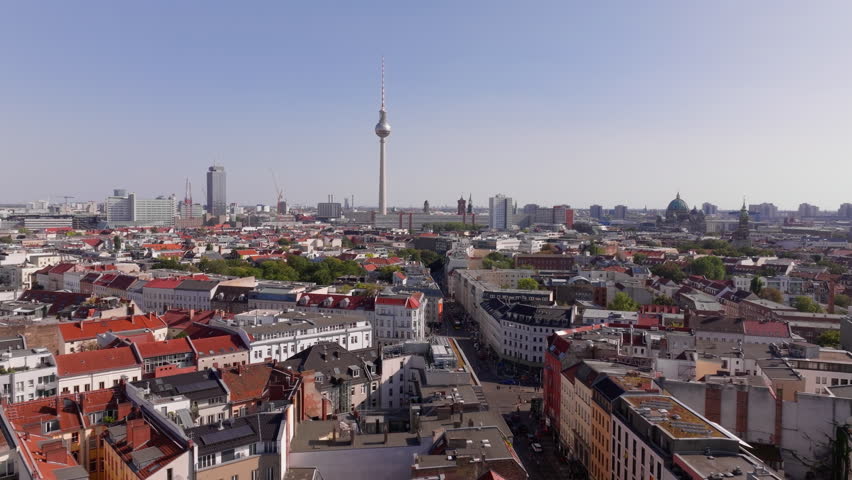 Aerial view of central Berlin, Germany, showcasing the iconic Fernsehturm television tower on Alexanderplatz and the surrounding cityscape on a sunny day