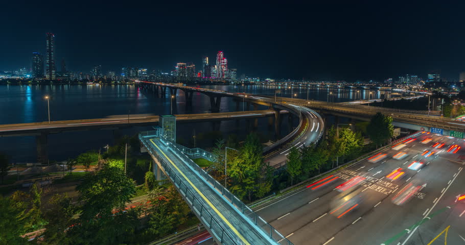 Busy Seoul Night Cars Traffic on Gangbyeongbuk-ro Expressway and Wonhyo Bridge, Many Cars Driving Riverside Han River in City Downtown Illuminated Yeouido Skyscraper Buildings in Backdrop -Time Lapse