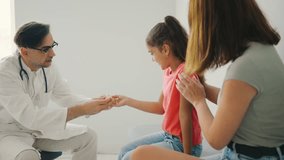 During a pediatric consultation, a doctor engages in a thorough discussion about health matters with a young patient and her caring mother - Powered by Shutterstock - Get 15% off with code: PIKWIZARD15