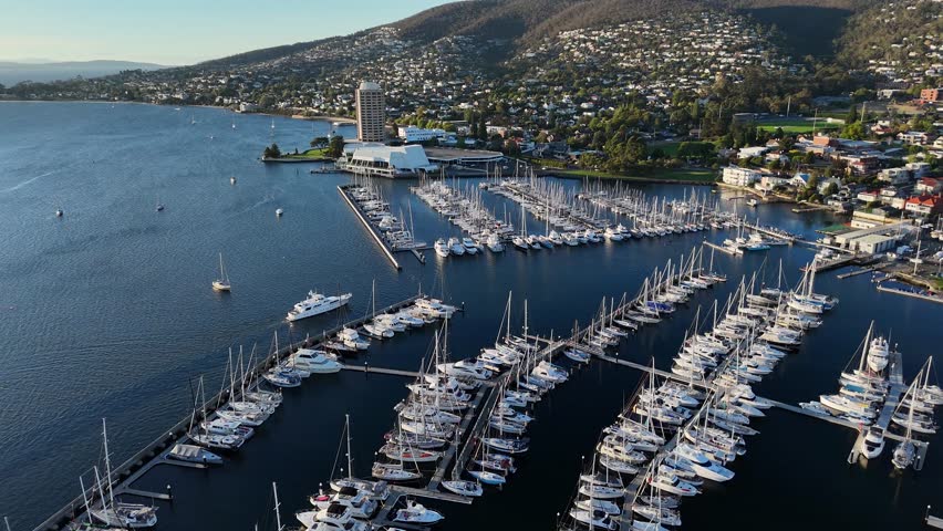 Boat arriving at The Royal Yacht Club of Tasmania at sunset, Hobart in Australia. Aerial drone view