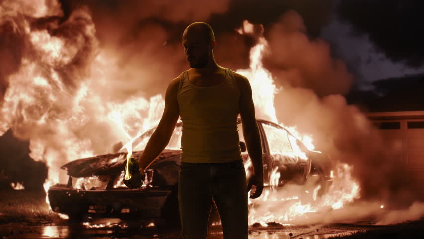 Silhouetted Man Standing Before Burning Car Violence Chaos Destruction Fire Dramatic