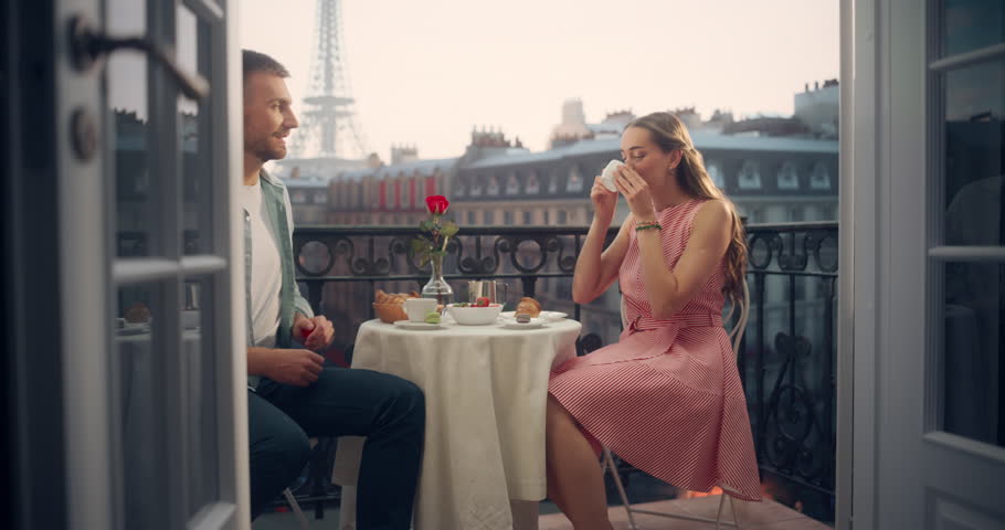 With the Majestic Eiffel Tower in the Backdrop, Young Man Proposing to His Girlfriend on a Beautiful Balcony in Paris. Her Elated Smile and Emotional Response Make the Scene Truly Unforgettable