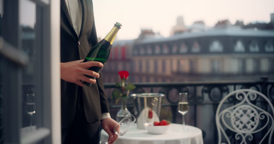 Anonymous Waiter Elegantly Pours Champagne on a Parisian Balcony, Overlooking the Eiffel Tower, Creating a Luxurious and Romantic Ambiance With Strawberries and a Rose on the Table
