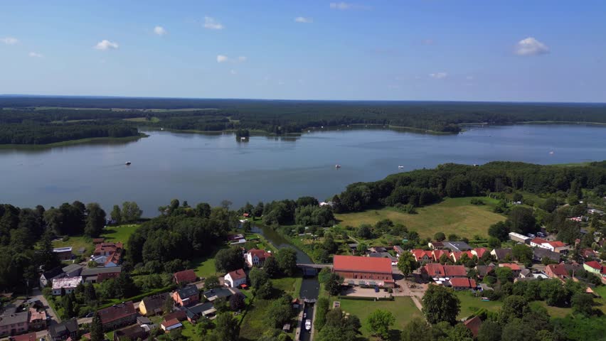 canal lock sluice being used by boats on a sunny summer day in germany Himmelpfort countryside Brandenburg. Lovely aerial view flight tilt down drone
