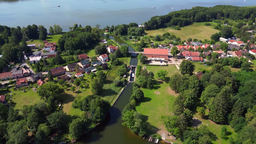 canal lock sluice being used by boats on a sunny summer day in germany Himmelpfort countryside Brandenburg. Dramatic aerial view flight drone shot footage from above