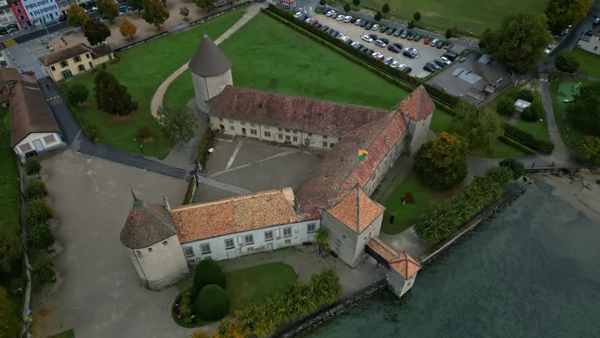 Orbit drone shot right above beautiful Rolle Castle in Vaud Switzerland