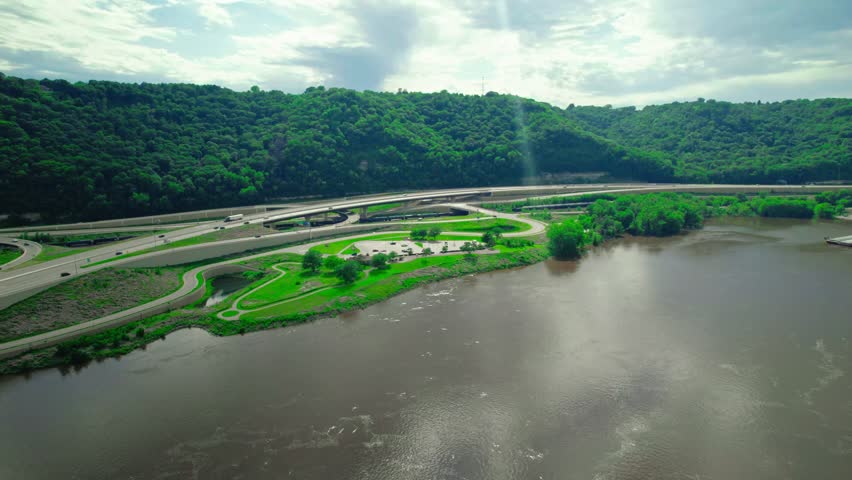 Aerial view of Minnesota Welcome Center Rest Stop near the Mississippi River, surrounded by green hills.