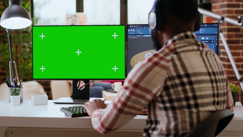 Male freelance designer works remotely on 3D prototypes using green screen and CAD software. Home workspace highlights the balance between productivity and comfort in industrial design. Camera B.