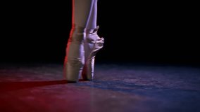 Closeup view of ballerina feet in pointe shoes in rehearsal room or stage. Professional female ballet dancer performing classic ballet steps on floor of studio, slow motion, classical art and culture - Powered by Shutterstock - Get 15% off with code: PIKWIZARD15
